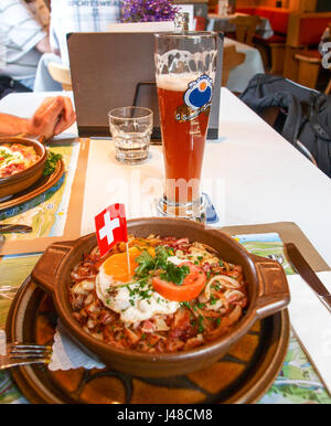 Oberalp, Svizzera - 1 Agosto 2016: piatto "patate roesti' chiamate con boccale di birra. Foto Stock