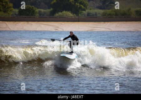 Una racchetta boarder surf a onde artificiali in piscina nel Conwy Valley sa come navigare Snowdonia, che è il primo nel mondo commerciale lago di surf Foto Stock