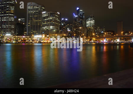 Una vista notturna di fronte Cockle Bay, il Porto di Darling, Sydney mostra riflessi nell'acqua di luci da ristoranti e il CBD e edifici Foto Stock