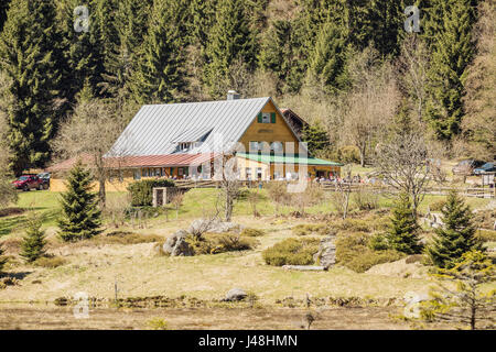 Cottage in riva al lago Kleiner Arbersee con lordo monte Arber, Baviera, Germania. Bella e soleggiata giornata di primavera in montagna. Foto Stock