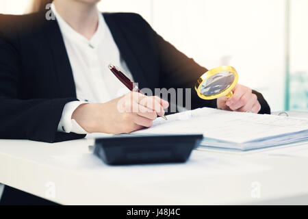 Concetto di audit - revisore con lente di ingrandimento di ispezionare i documenti di office Foto Stock