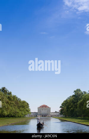 Monaco di Baviera, Germania. Xi Apr, 2017. Un gondoliere con la sua Gondola Veneziana e due passeggeri passa scivola sulle acque del canale centrale nella parte anteriore del paesaggio del palazzo di Nymphenburg a Monaco di Baviera, Germania, 11 aprile 2017. I visitatori al palazzo possono cavalcare su originale gondole veneziane durante l'estate, in commemorazione del veneto magnifica navi della corte del principe elettore Max Emanuel. Foto: Peter Kneffel/dpa/Alamy Live News Foto Stock