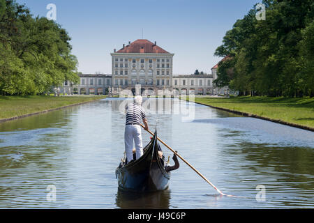 Monaco di Baviera, Germania. Xi Apr, 2017. Un gondoliere con la sua Gondola Veneziana e due passeggeri passa scivola sulle acque del canale centrale nella parte anteriore del paesaggio del palazzo di Nymphenburg a Monaco di Baviera, Germania, 11 aprile 2017. I visitatori al palazzo possono cavalcare su originale gondole veneziane durante l'estate, in commemorazione del veneto magnifica navi della corte del principe elettore Max Emanuel. Foto: Peter Kneffel/dpa/Alamy Live News Foto Stock