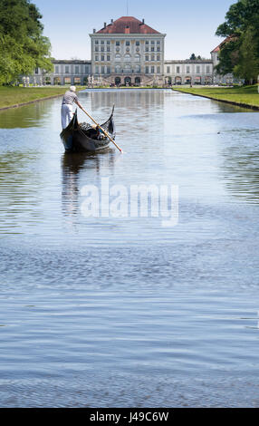 Monaco di Baviera, Germania. Xi Apr, 2017. Un gondoliere con la sua Gondola Veneziana e due passeggeri passa scivola sulle acque del canale centrale nella parte anteriore del paesaggio del palazzo di Nymphenburg a Monaco di Baviera, Germania, 11 aprile 2017. I visitatori al palazzo possono cavalcare su originale gondole veneziane durante l'estate, in commemorazione del veneto magnifica navi della corte del principe elettore Max Emanuel. Foto: Peter Kneffel/dpa/Alamy Live News Foto Stock