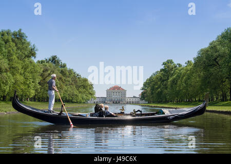 Monaco di Baviera, Germania. Xi Apr, 2017. Un gondoliere con la sua Gondola Veneziana e due passeggeri passa scivola sulle acque del canale centrale nella parte anteriore del paesaggio del palazzo di Nymphenburg a Monaco di Baviera, Germania, 11 aprile 2017. I visitatori al palazzo possono cavalcare su originale gondole veneziane durante l'estate, in commemorazione del veneto magnifica navi della corte del principe elettore Max Emanuel. Foto: Peter Kneffel/dpa/Alamy Live News Foto Stock