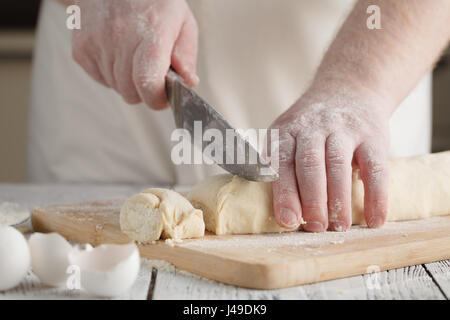 Lo chef cucina (preparazione cottage cheese pancakes) su una tavola di legno Foto Stock