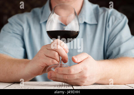 L uomo lo sniffing di vino rosso in un bicchiere, close up Foto Stock