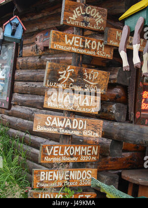 Segno di benvenuto in più lingue al di fuori di Log Cabin Doni, tourist souvenir shop in Whittier Alaska, Stati Uniti d'America. Foto Stock