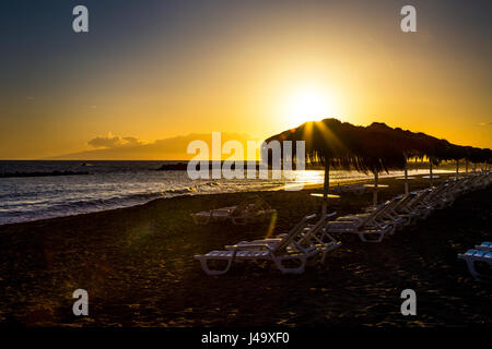 Ombrelloni al tramonto a Playa del Duque Beach a Tenerife, Spagna Foto Stock