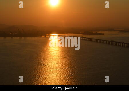 Il tramonto e il ponte. Ponte al di sopra della baia di Guanabara che collega Rio de Janeiro a Niterói, Brasile. Foto Stock