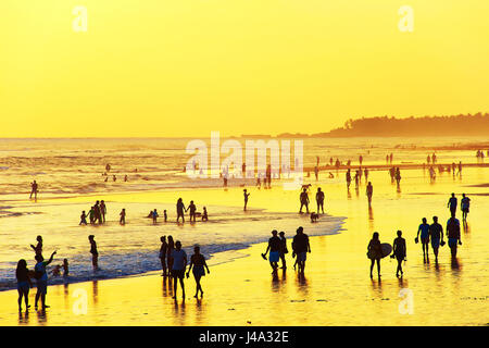 La gente camminare sulla spiaggia dell'oceano al tramonto. Isola di Bali, Indonesia Foto Stock