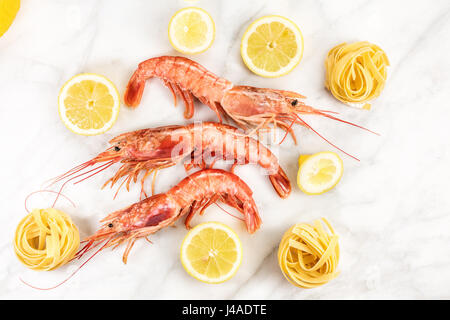 Materie gamberetti con limone e la pasta sul tavolo di marmo Foto Stock