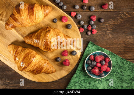 Croccanti croissant francesi con lamponi freschi e mirtilli Foto Stock