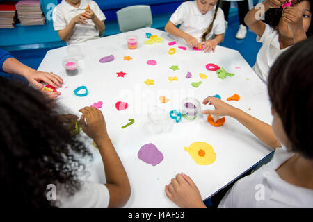 Kindergarten studenti forma di apprendimento con argilla colorata Foto Stock