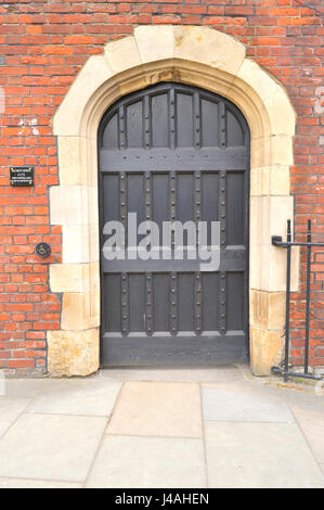 Grande portale ad arco con una solida porta di legno Foto Stock