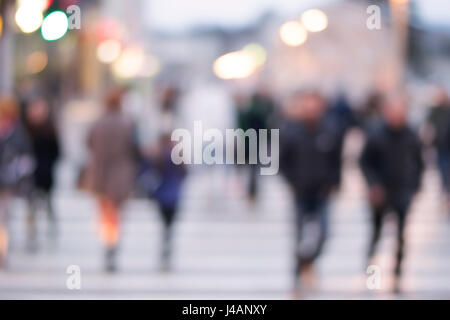 Immagine con sfocatura di movimento di una folla di persone che attraversano una strada di città all'attraversamento pedonale Foto Stock