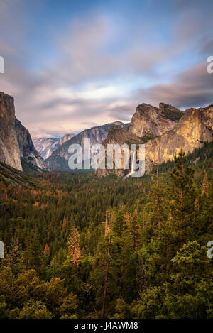 Valle di Yosemite Bridalveil e cadono al tramonto dalla vista di tunnel, California. Lunga esposizione. Foto Stock