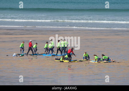 Scuola di Surf istruttori novizi di insegnamento su Fistral Beach in Newquay Cornwall fuga Scuola Surf Surf Surfer ai partecipanti il coaching di apprendimento Foto Stock