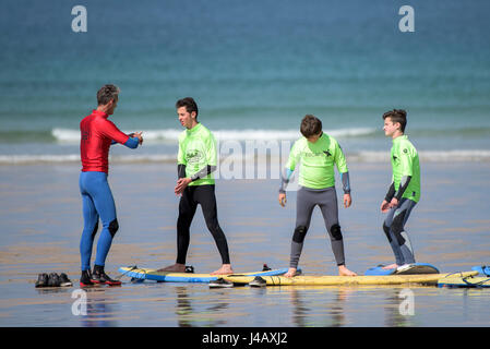 Una scuola di surf istruttore insegnamento novizi Newquay Cornwall Surf Surfer ai partecipanti imparare Coaching Didattica istruire Foto Stock