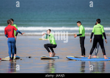 Una scuola di surf istruttore insegnamento novizi Newquay Cornwall Surf Surfer ai partecipanti imparare Coaching Didattica istruire Foto Stock