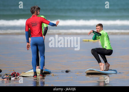 Una scuola di surf istruttore insegnamento novizi Newquay Cornwall Surf Surfer ai partecipanti imparare Coaching Didattica istruire Foto Stock