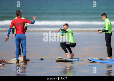 Una scuola di surf istruttore insegnamento novizi Newquay Cornwall Surf Surfer ai partecipanti imparare Coaching Didattica istruire Foto Stock