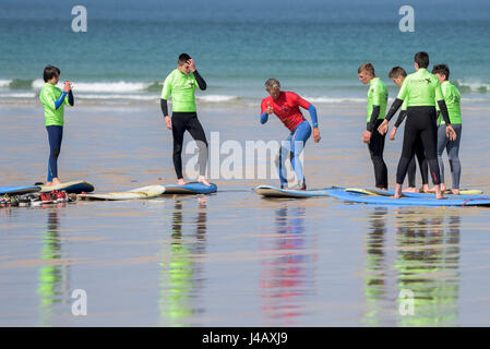 Una scuola di surf istruttore insegnamento novizi Newquay Cornwall Surf Surfer ai partecipanti imparare Coaching Didattica istruire Foto Stock