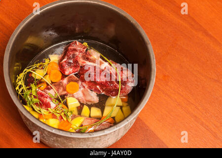 Ossa di manzo zuppa di brodo di cottura Ingredienti in saosepan sul tavolo Foto Stock