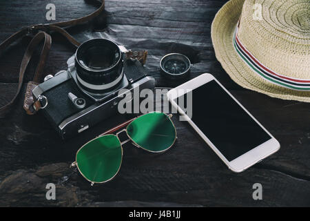 Accessori da viaggio sulla scrivania come la fotocamera occhiali bussola hat smart phone technology,attrezzature di viaggio per blogger concetto,avventura lifestyl gadget Foto Stock