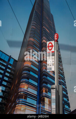 Una fermata degli autobus a firmare al di sotto di una costruzione palizzata che mostra la Foster-progettato la torre principale che è in costruzione su Shoreditch High Street, il 10 maggio 2017, a Londra, in Inghilterra. Foto Stock