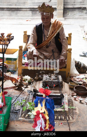 Uomo Santo facendo Offerte e preghiere per il Buddha il compleanno nel Tempio d'Oro - Hiranyavarna Mahavihara - Patan, o Lalitpur, Kathmandu, Nepal Foto Stock