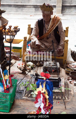 Uomo Santo facendo Offerte e preghiere per il Buddha il compleanno nel Tempio d'Oro - Hiranyavarna Mahavihara - Patan, o Lalitpur, Kathmandu, Nepal Foto Stock