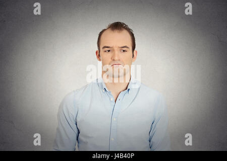 Closeup ritratto di arrabbiato triste infastiditi scettici, scontroso business man sconvolto lavoratore dipendente isolato muro grigio Sfondo. Le emozioni umane faccia expressi Foto Stock