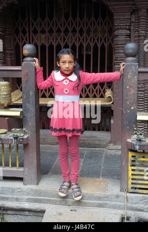 Giovani nepalesi ragazza vestita in rosa, tempio d'oro,Kathmandu. Foto Stock