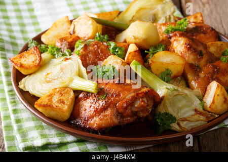 Cibo marocchino: pezzi di pollo al forno con semi di finocchio e patate close-up su una piastra orizzontale. Foto Stock