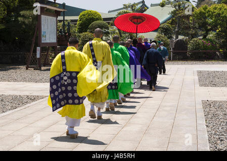 I sacerdoti buddisti in vesti luminose a piedi nei Naritasan Shinshoji Temple a Narita, in Giappone. I monaci appartengono al Chisan setta del Buddismo Shingon Foto Stock