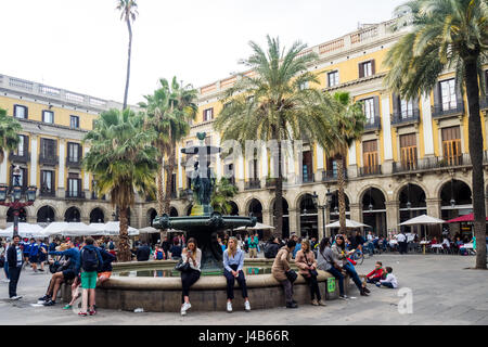 I turisti di seduta sul bordo della fontana centrale in Placa Reial, Barcelona, Spagna. Foto Stock