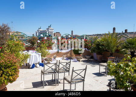 Decorazioni per matrimoni, impostazione tabella, composizioni floreali sulla terrazza sul tetto con vista Roma in background, Italia Foto Stock