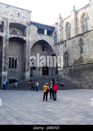 La gente seduta la scalinata che conduce al Saló del Tinell e la Cappella di Sant'Agata a Placa del Rei, Barcelona, Spagna. Foto Stock