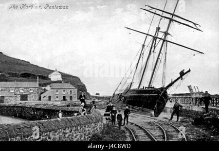Questa fotografia storica raffigura la ferrovia di Pentewan accanto a un veliero a tre alberi. L'immagine mostra l'interazione tra le tecnologie di trasporto dell'epoca, illustrando la storia industriale e marittima della regione. Foto Stock