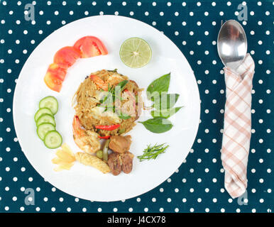 Cibo tailandese ,fritti di riso al gelsomino nel curry verde con carne (gamberetti,calamari,fegato di pollo e cuori di pollo) sormontato dimezzare limone verde,fette di pomodoro, cetriolo Foto Stock