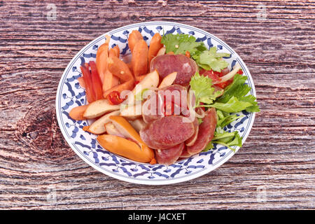 Popolare il cibo tailandese, piccante e aspro Insalata mista con salsiccia e salsiccia cinese servita nel modello tailandese piatto. Foto Stock