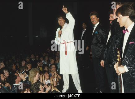 Austrian cantante e compositore Udo Juergens (M) sul palco accanto a membri del pepe Lienhard-band in un accappatoio bianco davanti ai suoi tifosi nel febbraio 1987. | Utilizzo di tutto il mondo Foto Stock