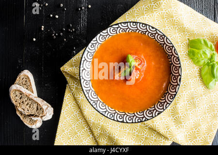 Vegetariano Zuppa di pomodoro su scuro dello sfondo in legno Foto Stock
