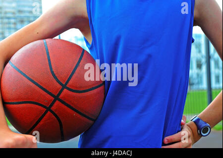 Silhouette di un giocatore di basket con la palla in mano, scena all'aperto Foto Stock