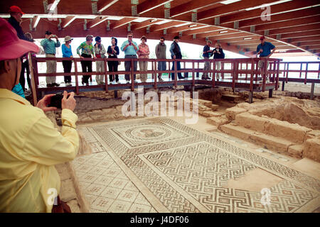 I turisti a piedi e guardare antico pavimento a mosaico. Kourion era una antica città sulla costa sud-occidentale di Cipro Foto Stock