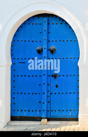 Portale ad arco con Blu porta chiodati, Africa, Nord Africa, Tunisia, Sidi Bou Said Foto Stock