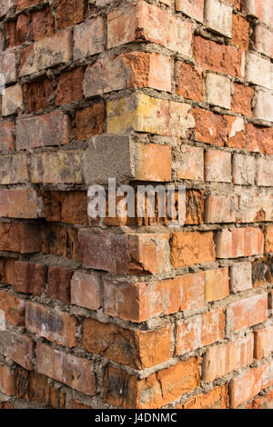 Angolo esterno di weathered edificio di mattoni rossi. Foto Stock