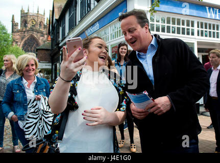 Nantwich, Regno Unito. 11 Maggio, 2017. L'ex primo ministro britannico David Cameron (R) anteriore si arresta per un selfie con una donna durante la campagna elettorale per il Partito conservatore in Nantwich, Gran Bretagna il 11 maggio 2017. Durante la sua visita, David Cameron si è incontrato con i cittadini locali per la campagna di voti prima delle elezioni generali che saranno il 8 giugno. Credito: Xinhua/Alamy Live News Foto Stock