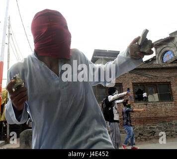 Srinagar Kashmir. Il 12 maggio 2017. .Un manifestante Kashmir buttare mattoni. Scontri scoppiati tra dimostranti e forze di sicurezza in downtown area Nowhatta di Srinagar. Gruppi di giovani si concedeva sloganeering e pietra- della concia a forze di sicurezza indiane subito dopo Venerdì preghiere congregazionale. Secondo la relazione, 102 civili disarmati sono stati uccisi in 135 giorni di disordini che è stato scatenato dalla uccisione di luglio 8 di Hizbul Mujahideen comandante Burhan Wani dalle forze armate. Credito: sofi suhail/Alamy Live News Foto Stock